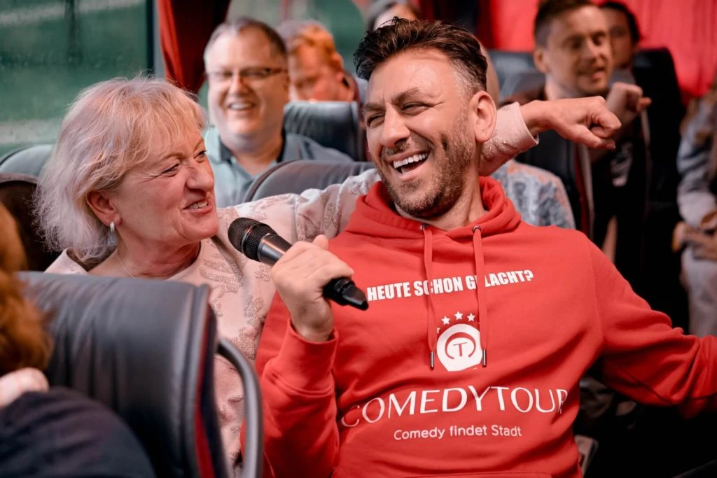 a man in a red shirt with a microphone in front of a woman